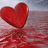 A red heart floats over water with a reflection, while black text on red background reads 'my heart dropped when he said like a sis' and small hearts scatter below.