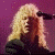 A pixelated animated image of a person with long blonde hair singing into a microphone against two-toned backgrounds.