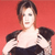 A pixelated image of a person with short brown hair wearing a black off-shoulder top against a solid red background.
