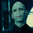 Pixelated static image of a bald figure with pale skin, dark eyes, and neutral expression against dark blue background.