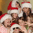 Pixelated image of multiple figures wearing Santa hats with red and white trim, some faces visible in a clustered composition.