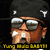 Pixelated image of a character with brown skin, large silver sunglasses, and dark hair against black background.