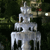 A pixelated silver candle with three tiers and dripping wax against a dark green background.
