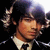 Pixelated image of a person with dark hair and light skin wearing a white shirt, set against black background.