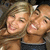 Two people with light brown hair smiling closely together in a pixelated image, one wearing dark clothing.