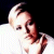Static pixelated image of a person with light hair and dark clothing against black background, wearing white top with visible shoulder strap.