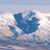 Blue and white pixelated shape resembling a stylized animal or abstract form against a light blue and white background.