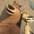A pixelated cartoon bear and giraffe stand side-by-side, the bear smiling widely with a dark scarf, the giraffe holding a striped object.