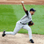 A baseball pitcher in mid-throw on a field, captured across four showing arm and leg motion