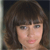 A static pixelated image shows a person with brown hair and bangs against a dark background, with visible skin tones and subtle facial features.