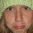 A static image of a person with light brown hair wearing a green knit hat, positioned above another person with dark brown hair and no headwear.