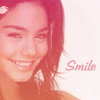 A static image of a person with long brown hair wearing a white top, smiling with visible teeth, with the word 'Smile' in red text on the right side.