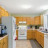 Pixelated static image of a kitchen interior with wooden cabinets, a refrigerator, and a countertop with objects.