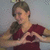 A person in a red shirt forms a heart shape with hands against a light gray background, with subtle variations in hand position and facial expression across frames.