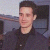 Static pixelated image of a person in dark clothing against an indistinct background with visible dithering and low-resolution rendering artifacts.