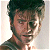 Pixelated portrait of a person with dark hair and light skin, wearing a dark shirt against a pale background.