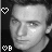 Black-and-white pixelated portrait with heart and 'B' symbols, showing subtle facial expression changes between frames.