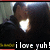Pixelated image of a person with dark hair and a dark jacket, mouth open in a bright white shape, with text below reading 'i love yuh!' in white block letters.