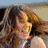 A woman with long brown hair appears in six distinct poses across a , wearing various tops including white and sleeveless styles