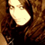 A pixelated image of a person with long brown hair wearing dark clothing, showing two side-by-side views where the right view has slightly different facial features.