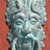Pixelated static image of a stylized face with closed eyes, rendered in teal and gray tones against a solid reddish-brown background.