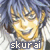 Pixelated image of a smiling character with golden hair and blue eyes, wearing a dark jacket over a light shirt, with the text 'skurai' at the bottom.