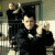 A pixelated animated sequence shows a person in dark clothing making hand gestures against a blurred background with vertical lines.