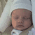 A static image divided into four quadrants showing a baby, blue footprints with date text, and a heart-shaped nameplate.