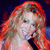 A pixelated close-up of a person with long, wavy, light brown hair holding a black microphone against a dark blue background.