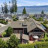 Pixelated landscape showing a house with dark roof, green trees, and blue sky background. Static image with visible pixelation.