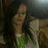 Pixelated static image of a figure with light skin tone holding an object, wearing green and white lower body attire against dark background.