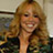 Static 48x48 pixel icon showing a smiling woman with long wavy blonde hair wearing a dark top, set against an indistinct background.