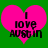 Two identical pixelated pink hearts on green background with black text reading "I LOVE AUSTIN" in blocky font.