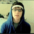Pixelated static image of a person with long dark hair wearing a white headband and blue hoodie against light background.
