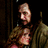 A pixelated image shows two figures embracing against a dark background with overlaid text fragments.