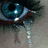 A split-screen image shows a close-up of a blue eye with tears on the left and pixelated text on a dark blue background on the right.