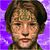 Pixelated image of a person with short brown hair and green clothing against a purple background, next to a metallic star-shaped icon with a central symbol.