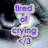 Pixelated text reads 'tired of crying <3' in purple letters on light gray rectangular backgrounds against a dark, blurry abstract backdrop.