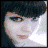 Pixelated close-up of a person with dark hair and light skin, showing facial features and clothing details