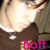 A person wearing a brown shirt with white collar and silver pendant necklace, pink text 'hott' overlaid on lower portion.