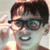 Pixelated image of a person with dark hair and glasses making a hand gesture, alongside red text reading "Squince" and black text reading "The Sandlot" on white background.