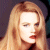 Static pixelated image of a person with long light brown hair, closed eyes, and red lips against dark background.
