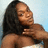 A person with long dark hair wears a white strapless top against a light blue background, with hand near neck in three sequential poses.