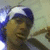 A person wearing a blue and white striped headband lies on a light-colored surface with arms crossed, showing three sequential facial expressions.