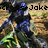 Pixelated image of a character in blue and black attire holding a green glowing object, with 'Joke' text above.