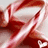 Red and white striped candy cane with yellow text reading 'Merry Christmas' on a light background.