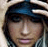 Pixelated image of a person with light-colored hair wearing a dark blue cap, next to text reading "Can't Hold us Down!" in pixelated font.