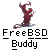 Pixelated figure in dark red outfit with white accents stands on one leg, arms raised above head against gray background; text below reads "FreeBSD Buddy".