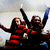 Two figures in red and black attire with raised arms against a light background, rendered in pixelated style.
