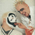 Two side-by-side frames of a pixelated animated icon showing two men in white shirts with black text on them, one holding a microphone and the other making hand gestures.